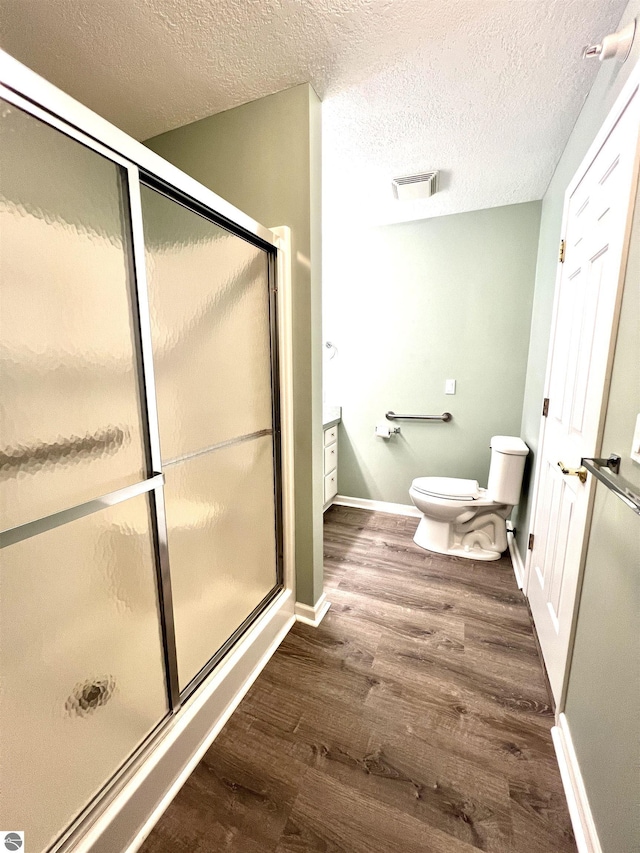624 S Lake St, Cadillac, MI 49601 - bathroom with visible vents, a stall shower, wood finished floors, and a textured ceiling