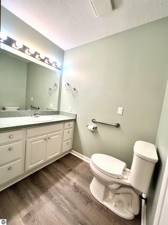 624 S Lake St, Cadillac, MI 49601 - half bath with toilet, a textured ceiling, wood finished floors, and vanity