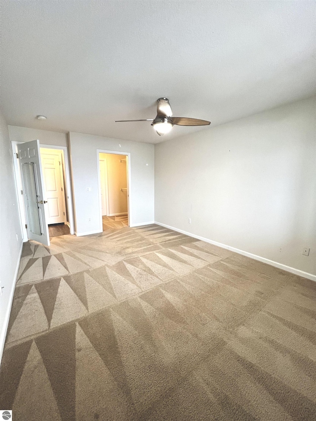 624 S Lake St, Cadillac, MI 49601 - spare room with light carpet, baseboards, a ceiling fan, and a textured ceiling