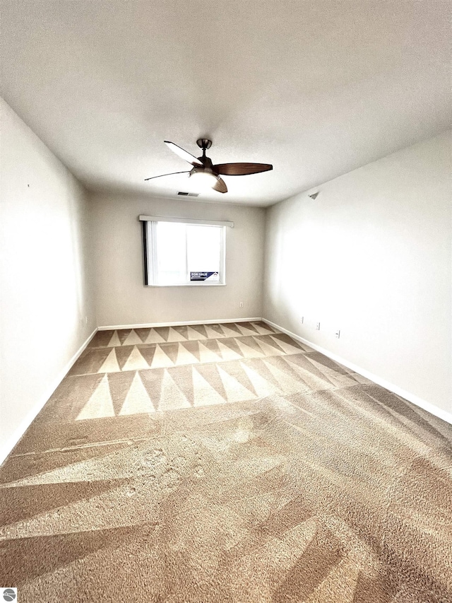 624 S Lake St, Cadillac, MI 49601 - carpeted empty room with visible vents, baseboards, and a ceiling fan