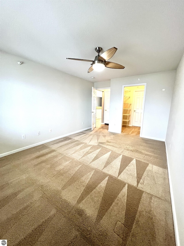 624 S Lake St, Cadillac, MI 49601 - carpeted spare room featuring baseboards, a textured ceiling, and ceiling fan