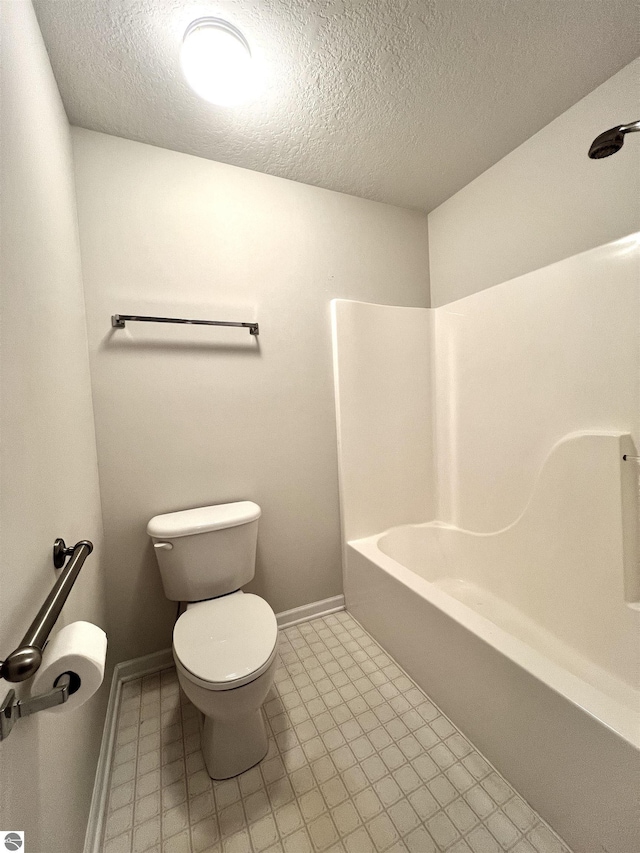624 S Lake St, Cadillac, MI 49601 - bathroom with toilet, baseboards, and a textured ceiling