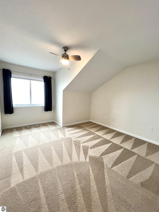 624 S Lake St, Cadillac, MI 49601 - bonus room featuring baseboards, a ceiling fan, light colored carpet, and a textured ceiling
