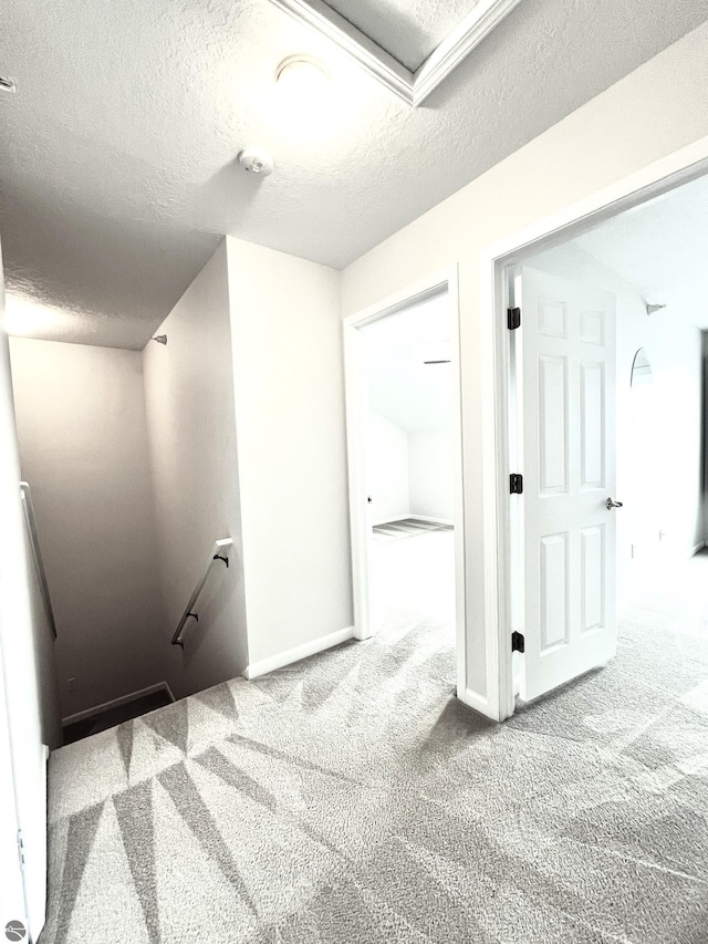 624 S Lake St, Cadillac, MI 49601 - corridor with an upstairs landing, a textured ceiling, baseboards, and carpet