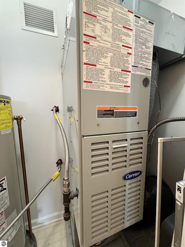 624 S Lake St, Cadillac, MI 49601 - utility room with gas water heater, visible vents, and heating unit