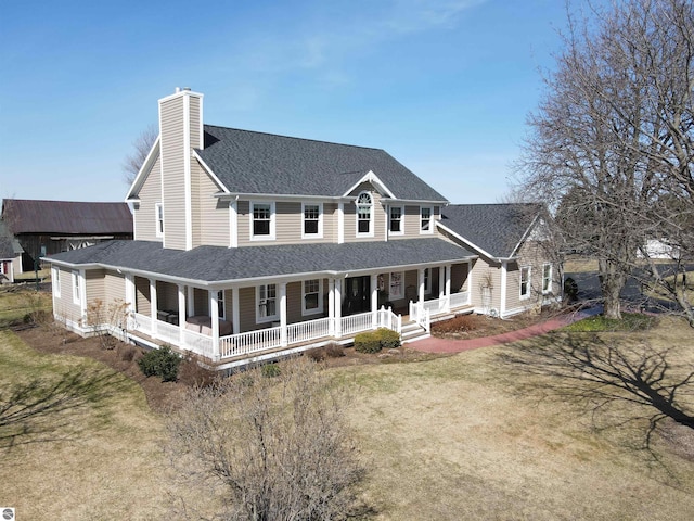 back of property with a porch, roof with shingles, a chimney, and a yard