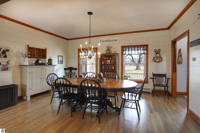 dining area featuring a chandelier, light wood-style floors, and ornamental molding
