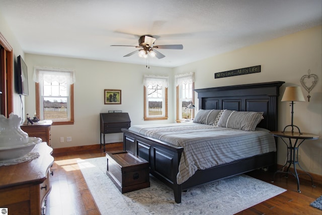 bedroom featuring ceiling fan, baseboards, and wood finished floors
