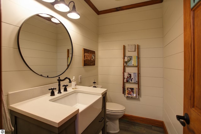 half bathroom with vanity, toilet, and wood finished floors