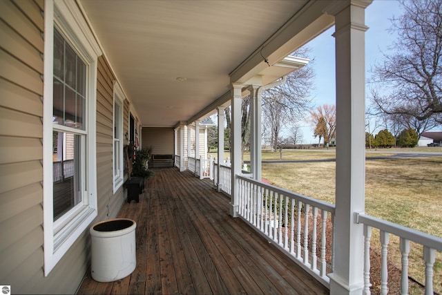 wooden terrace with a porch and a lawn