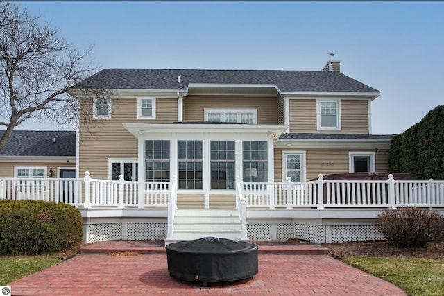 back of house featuring a patio, a wooden deck, and a shingled roof