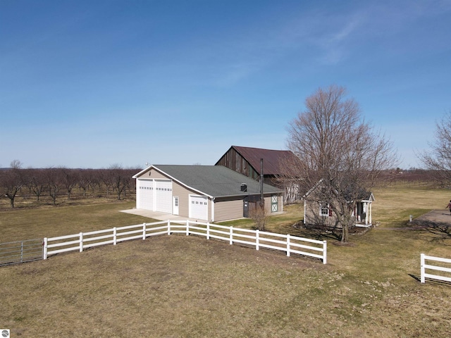 exterior space featuring fence, driveway, and a rural view