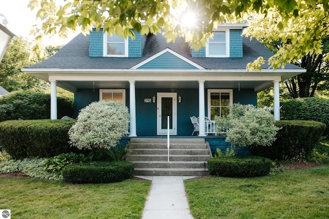 215 N Saint Marys St, Suttons Bay, MI 49682 - bungalow-style home featuring a front yard, a porch, and a shingled roof
