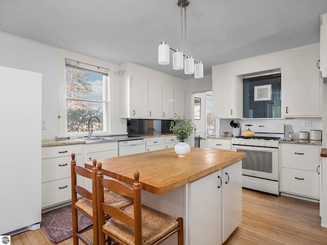 215 N Saint Marys St, Suttons Bay, MI 49682 - kitchen with light wood-style flooring, white cabinets, white appliances, and a sink
