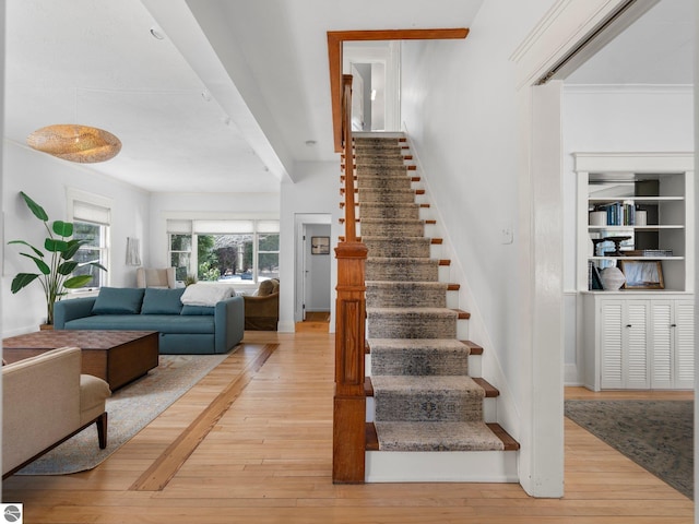215 N Saint Marys St, Suttons Bay, MI 49682 - stairs featuring ornamental molding, built in features, baseboards, and hardwood / wood-style flooring