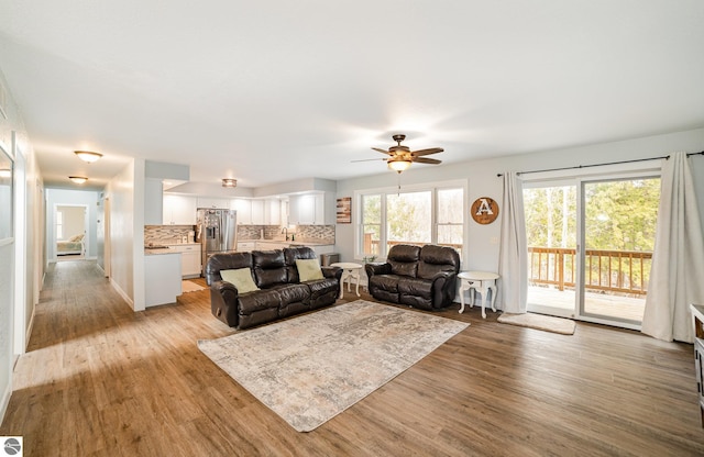 living room featuring light wood-style floors and a ceiling fan