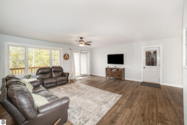 living area with dark wood-style flooring, baseboards, and ceiling fan