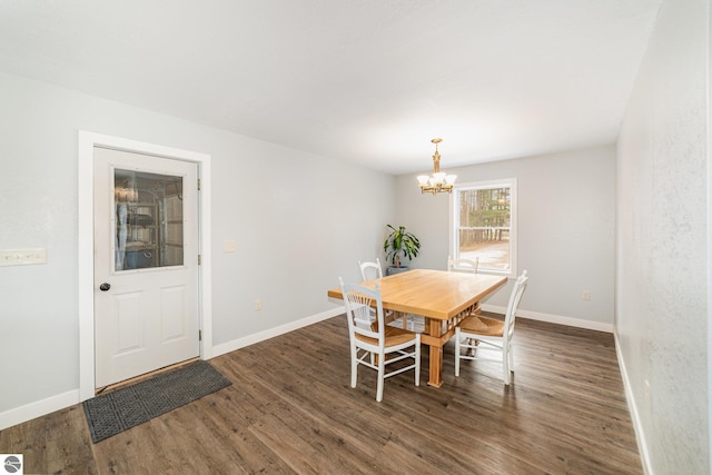 dining area with dark wood-style flooring, baseboards, and a notable chandelier
