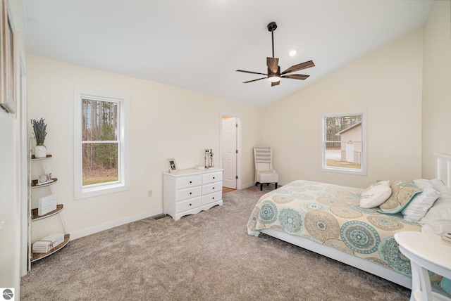 bedroom featuring light colored carpet, baseboards, multiple windows, and vaulted ceiling