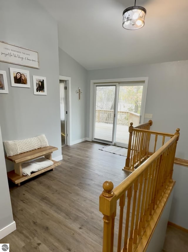 interior space with wood finished floors, baseboards, and vaulted ceiling