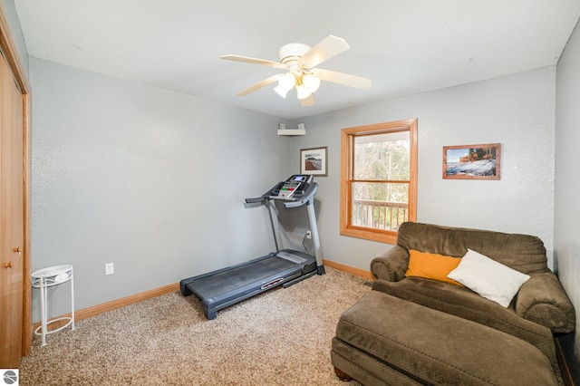 exercise area featuring baseboards, a ceiling fan, and carpet