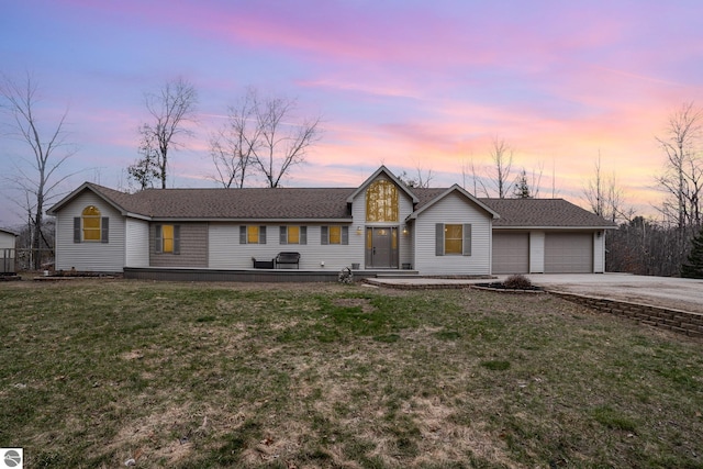 view of front of house featuring an attached garage, driveway, and a front yard