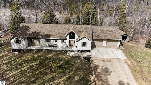 view of front of property with concrete driveway, a front yard, and an attached garage