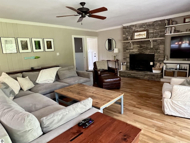 living room with a fireplace, ceiling fan, crown molding, and wood finished floors