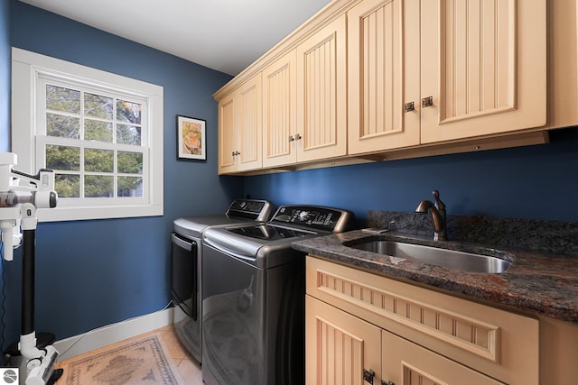 laundry area with washer and clothes dryer, a sink, baseboards, cabinet space, and light tile patterned floors