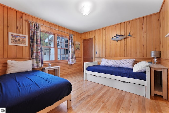 bedroom with wood-type flooring and wood walls