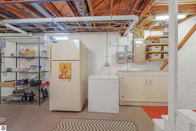 washroom featuring concrete block wall, electric panel, and laundry area