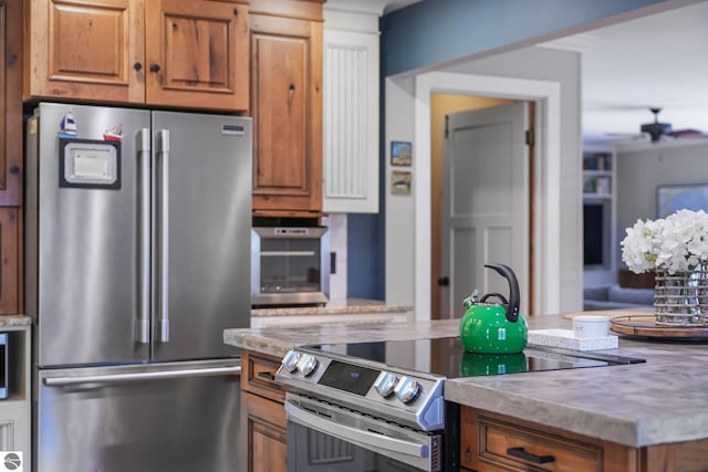 kitchen with brown cabinets, a ceiling fan, and stainless steel appliances
