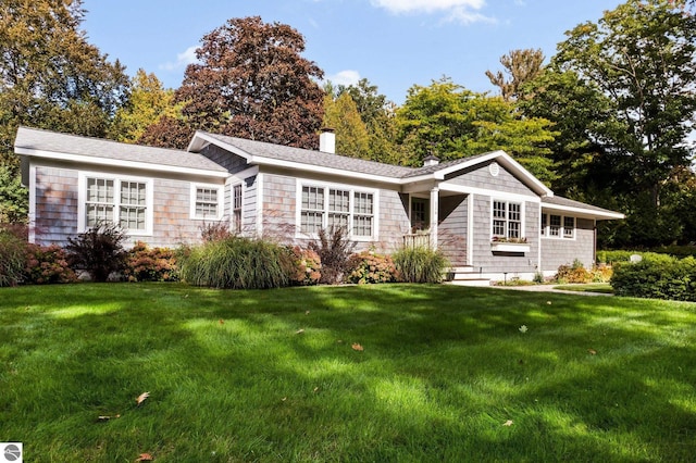 ranch-style home with a chimney and a front yard