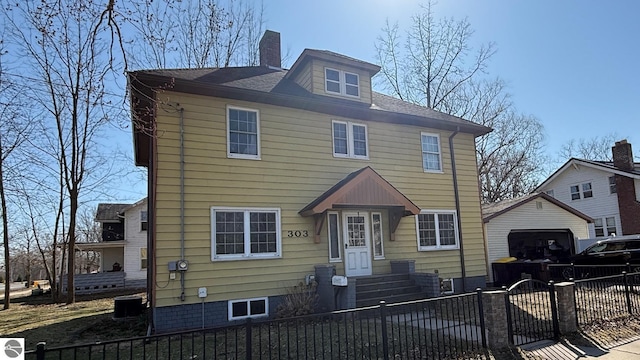 303 W Washington Ave, Saint Louis, MI 48880 - american foursquare style home featuring central AC, a shingled roof, a garage, a chimney, and a fenced front yard
