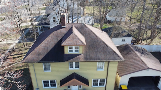 303 W Washington Ave, Saint Louis, MI 48880 - view of side of home featuring roof with shingles and a chimney