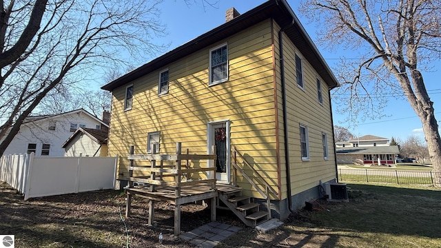 303 W Washington Ave, Saint Louis, MI 48880 - back of house with a chimney, fence, and central air condition unit