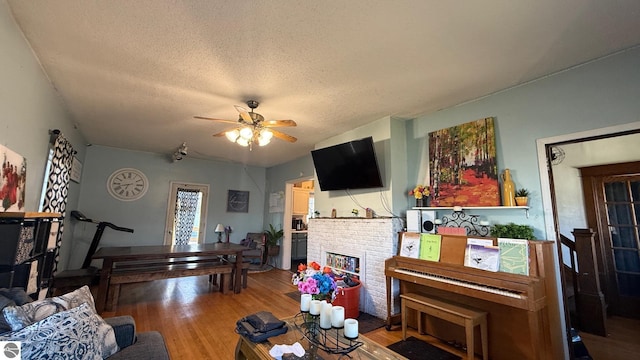 303 W Washington Ave, Saint Louis, MI 48880 - living room featuring light wood-style flooring, ceiling fan, a textured ceiling, and a fireplace