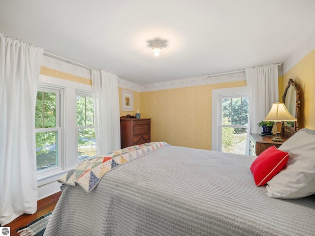 bedroom featuring wallpapered walls and wood finished floors