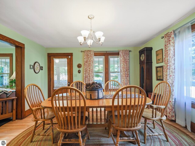 dining room featuring a chandelier, light wood-style flooring, and baseboards