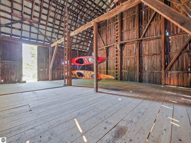 miscellaneous room with high vaulted ceiling and wood-type flooring