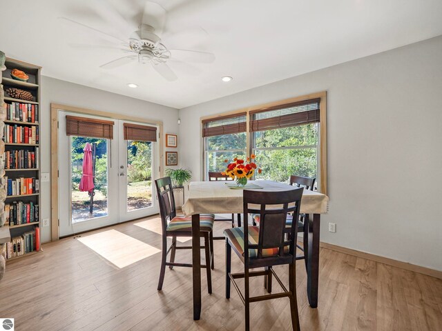 dining area with light wood-type flooring, a healthy amount of sunlight, baseboards, and a ceiling fan