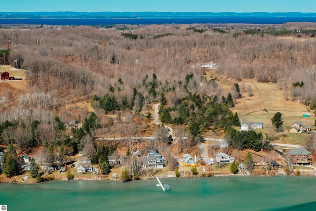 drone / aerial view with a residential view, a wooded view, and a water view