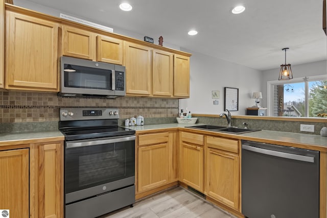 kitchen with light wood-style floors, a sink, backsplash, and stainless steel appliances