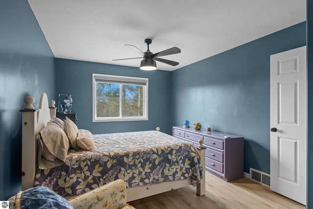 bedroom with visible vents, light wood-type flooring, baseboards, and ceiling fan