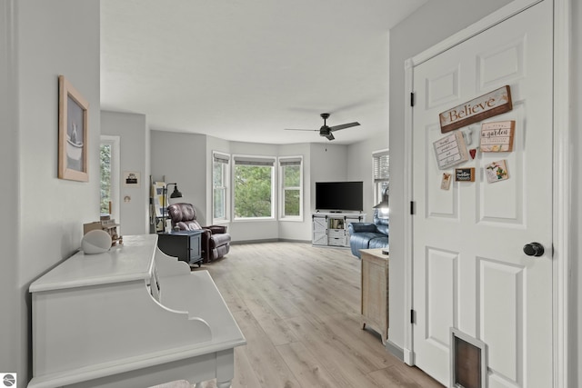 interior space with ceiling fan and light wood finished floors