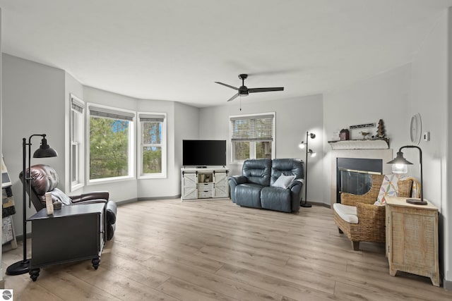 living room featuring a healthy amount of sunlight, wood finished floors, and a ceiling fan