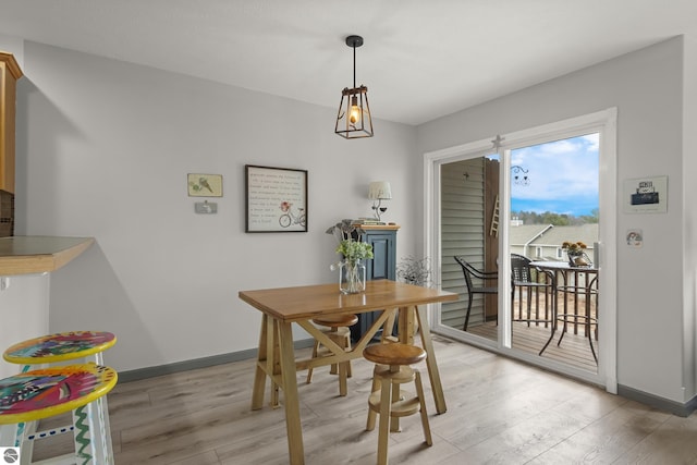 dining room with baseboards and light wood-type flooring