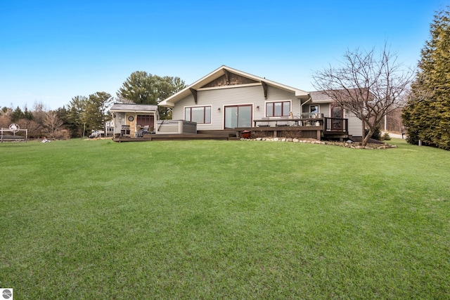 rear view of house featuring a deck and a lawn
