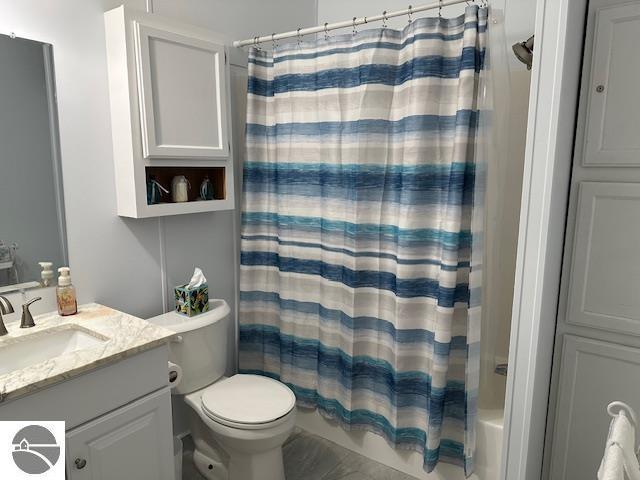 full bathroom featuring toilet, vanity, and shower / bath combo with shower curtain