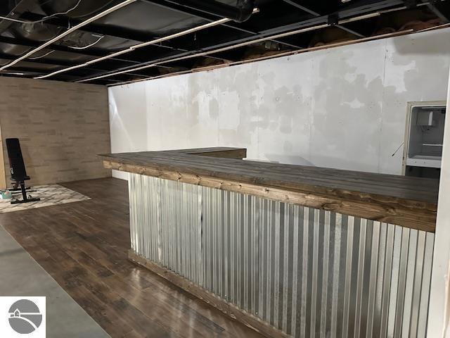 basement featuring dark wood-type flooring and a bar